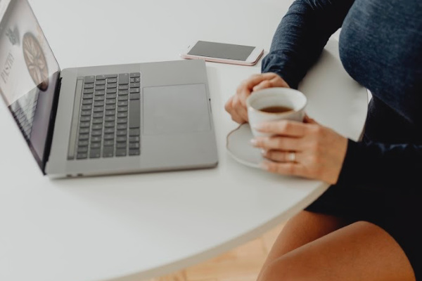 Woman with a cup of tea and a laptop