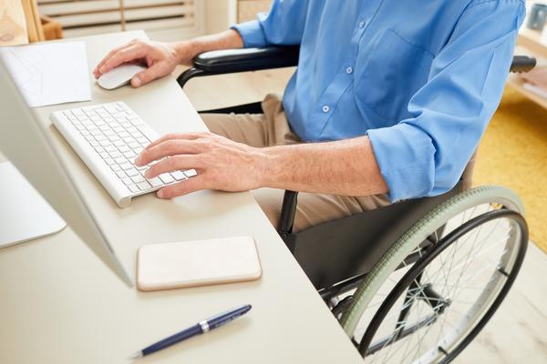 man wearing denim shirt working at desk on laptop